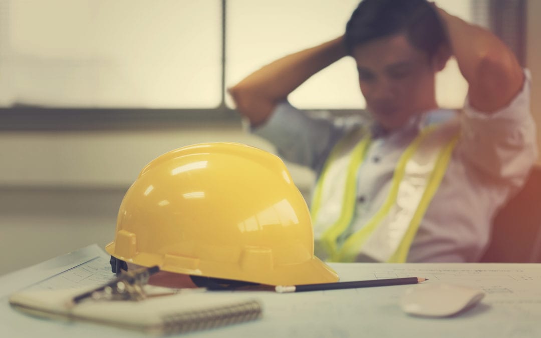 Tired industrial worker with hard hat off